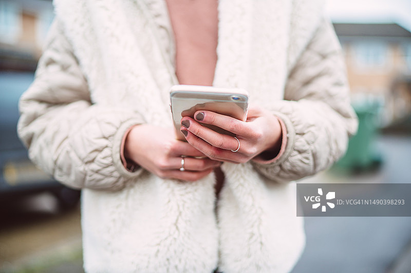 女士涂色美甲手持智能手机街拍图片素材