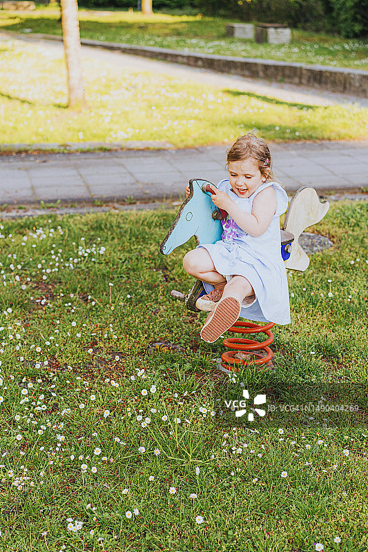 快乐小女孩在操场骑马图片素材