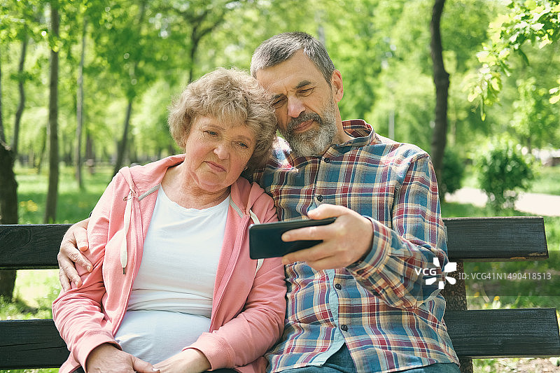 老年夫妇在户外观看视频图片素材