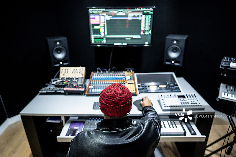 录音棚里使用调音台的男制作人背影图片素材