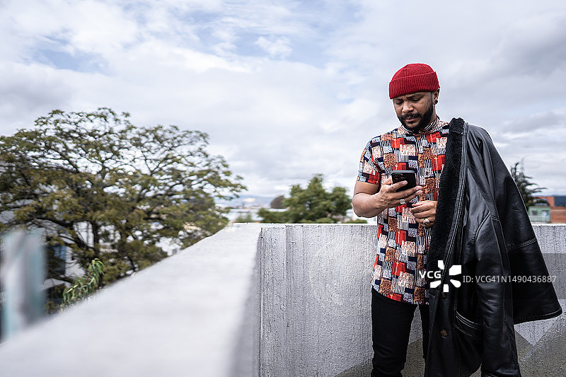 中年男人在家里的阳台上使用手机图片素材