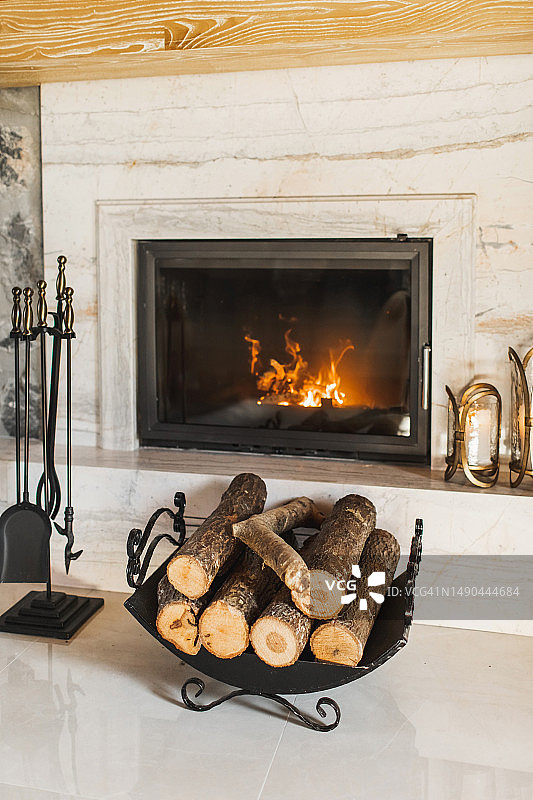燃烧的壁炉旁的木柴和壁炉工具图片素材