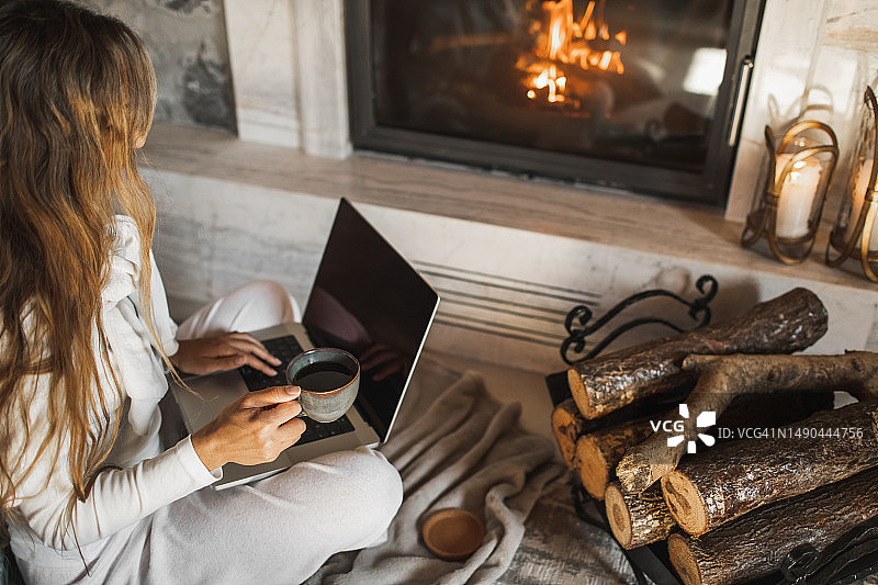 女人在壁炉前用电脑图片素材