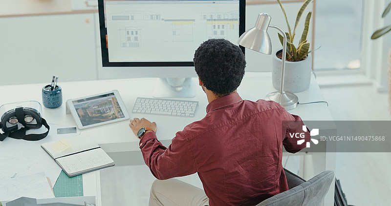 在办公室里，建筑师男人在电脑和平板电脑上设计数字平面图或蓝图。创意和建筑，男性设计师在桌面上为一个项目工作图片素材