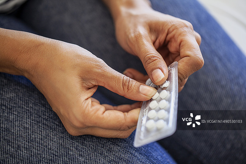 人们从泡罩包装中取药丸的手部特写图片素材