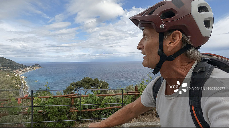 年长男人在乡间小路上骑自行车图片素材