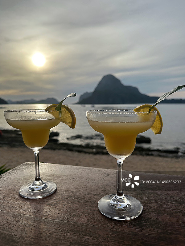 日落时分菲律宾桌上的两杯青柠玛格丽特鸡尾酒图片素材