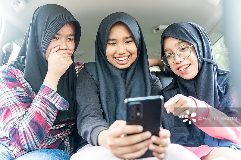 少女们在智能手机上分享照片图片素材