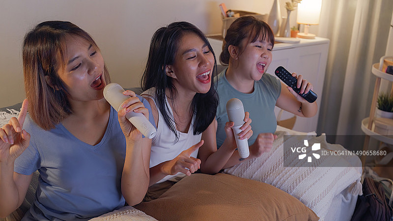 年轻的亚洲女性朋友在丰富多彩的家庭派对上唱歌图片素材