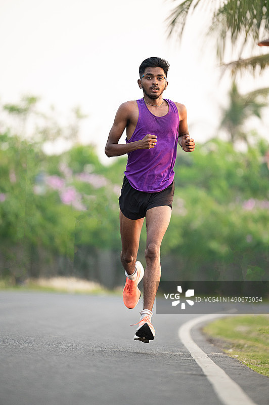 在水泥路上训练的年轻亚洲运动员图片素材