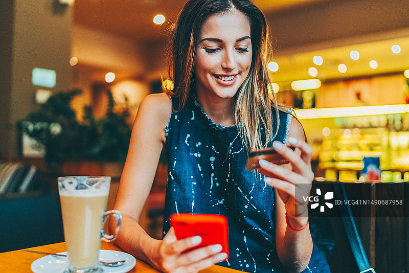 在咖啡馆进行在线支付的女人图片素材