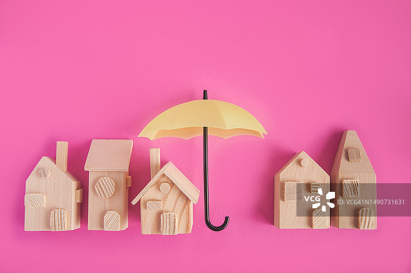 粉色背景空雨伞和模型房屋图片素材
