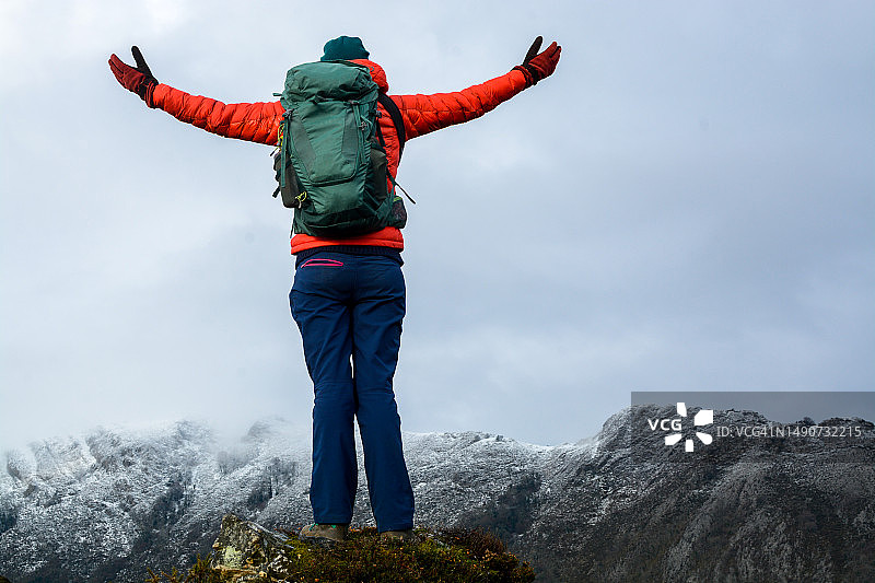 冬季山顶伸展双臂的女子背影图片素材