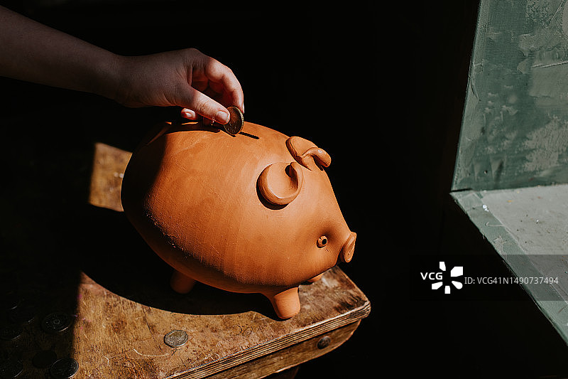 儿童将钱存入储钱罐的简约图像图片素材