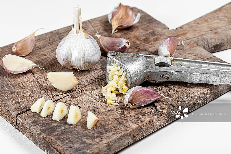 旧砧板上的大蒜球，大蒜压榨器和蒜瓣，罗马尼亚图片素材