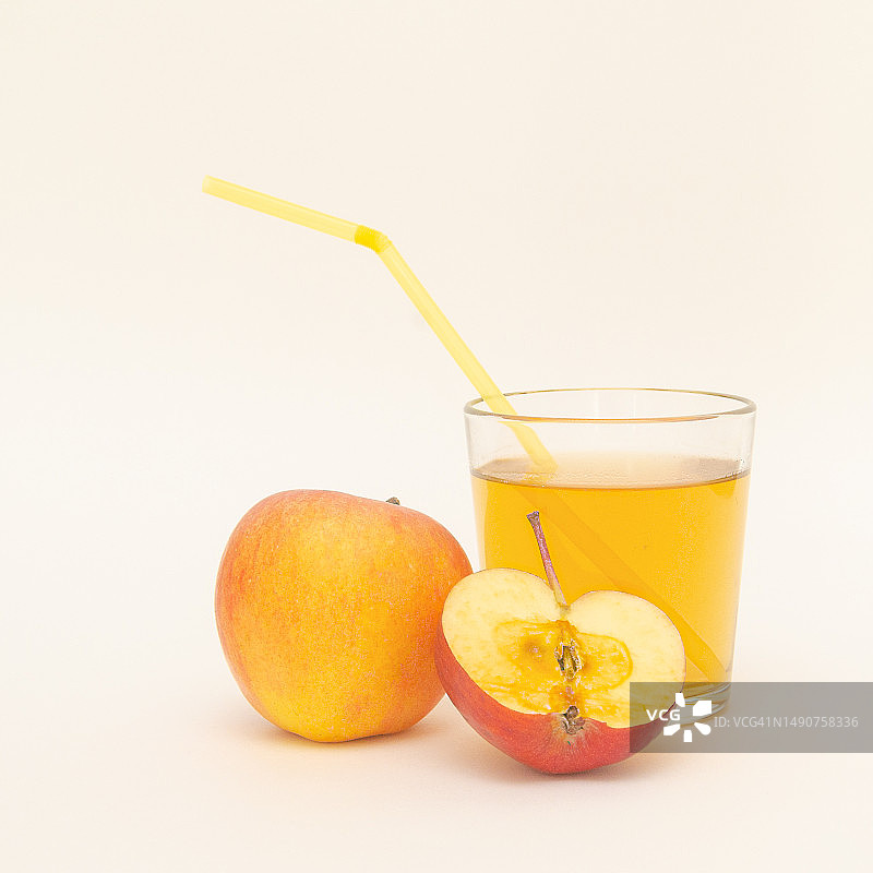 一杯苹果汁，配吸管和少量苹果，白色背景，罗马尼亚图片素材