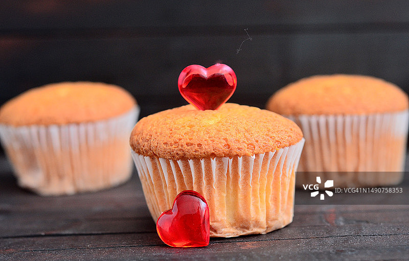 木制背景上的爱情纸杯蛋糕特写图片素材