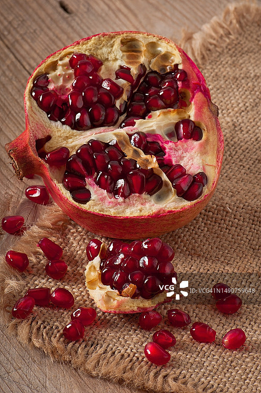 木质背景和粗麻布上的石榴籽图片素材