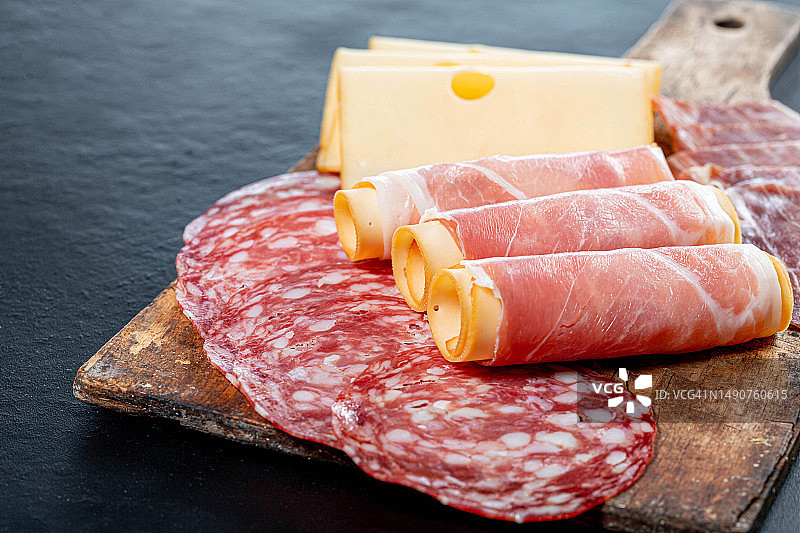 萨拉米香肠、哈蒙火腿、火腿和奶酪切片，放在罗马尼亚老式厨房木板上图片素材