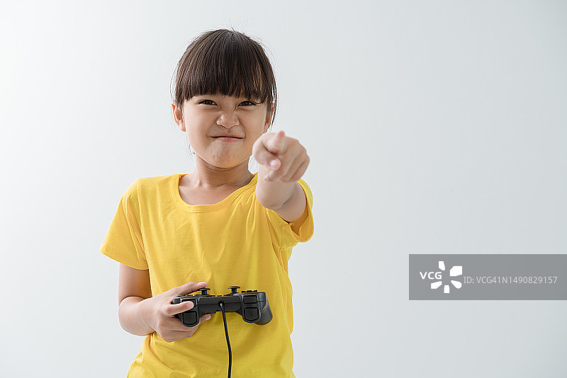 生气的女孩玩游戏机并指着脸，白色背景隔离图片素材