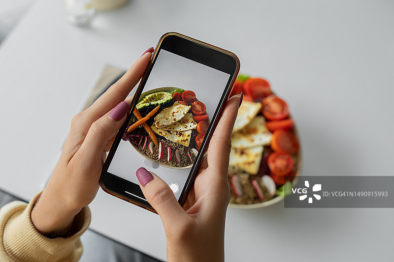 女人拍摄藜麦和哈罗米奶酪素食碗图片素材