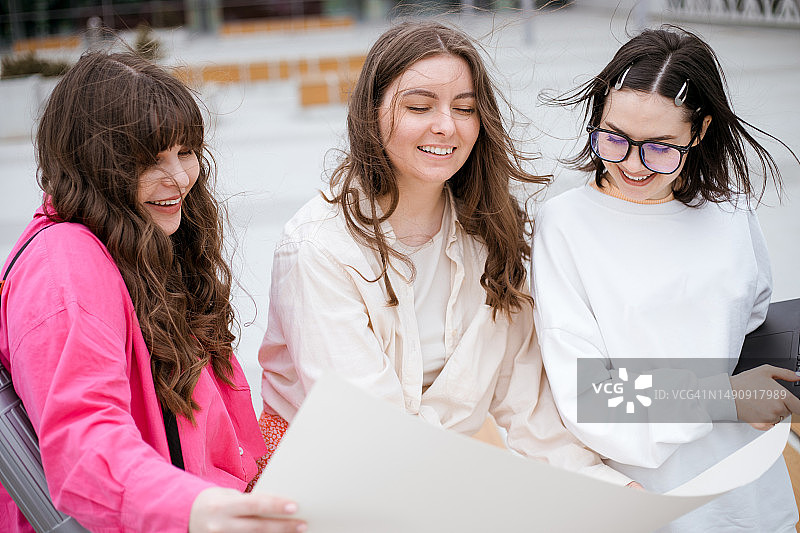 三个有魅力的Z世代女人拿着白纸微笑图片素材