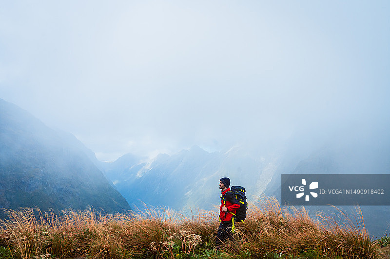 独自旅行者携带专业旅行装备登上山顶图片素材