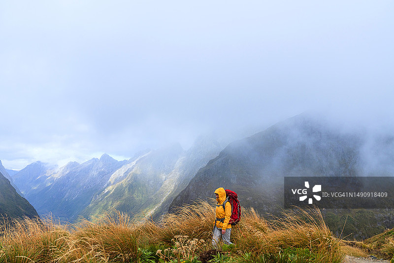 女登山者背着背包探索荒野图片素材