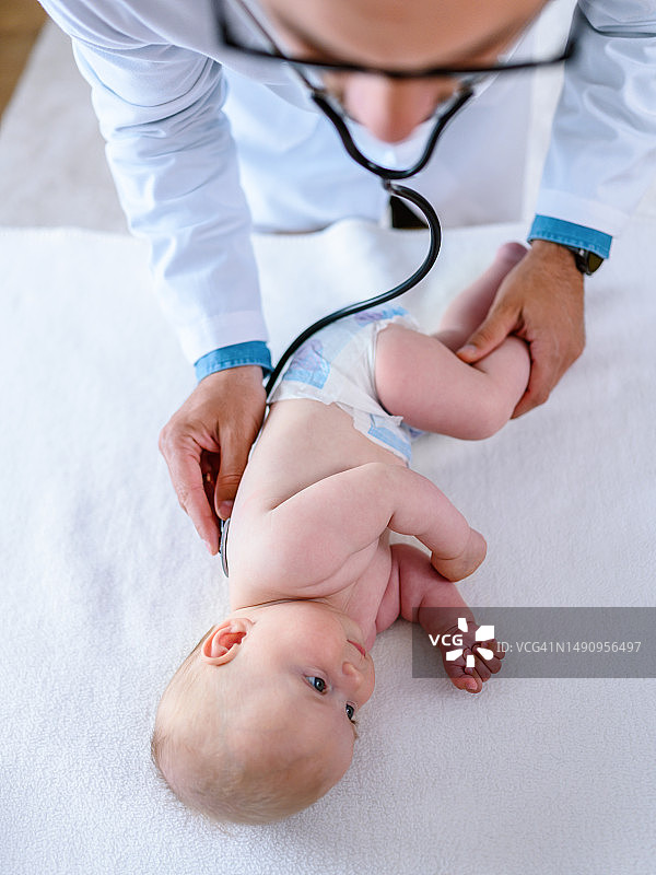 微笑的儿科医生用听诊器听诊宝宝图片素材