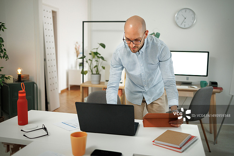 在办公室使用笔记本电脑的年轻男士图片素材