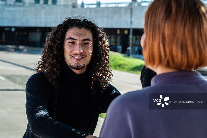 在街上和朋友聊天的年轻男人图片素材