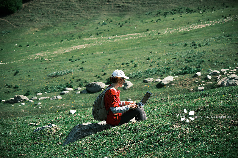 在山区使用笔记本电脑的快乐中年妇女图片素材