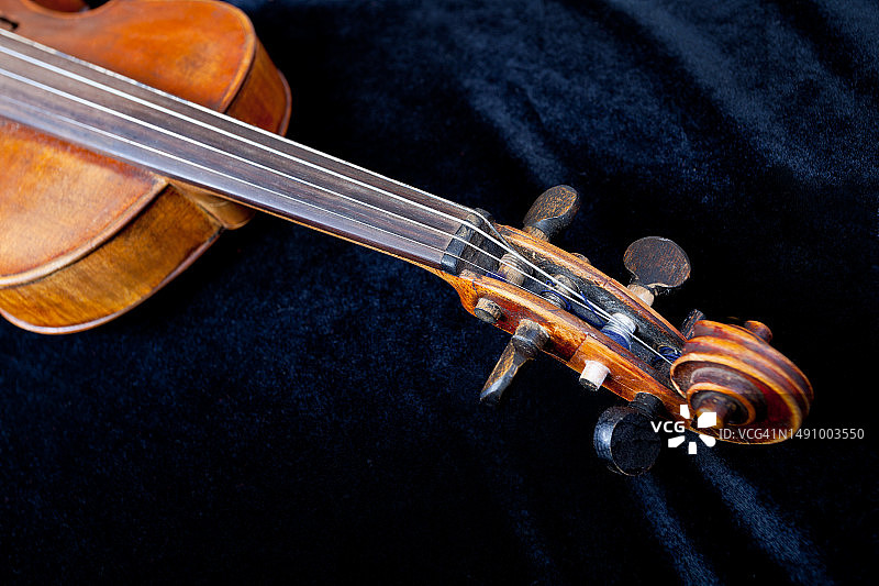 罗马尼亚黑色天鹅绒背景上的小提琴弦轴箱图片素材