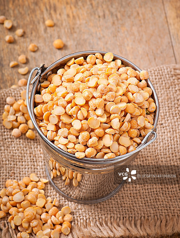 木制背景上桶中的干豌豆，罗马尼亚图片素材