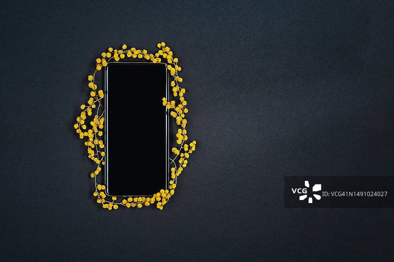 法国黑色背景上的黄色智能手机特写图片素材
