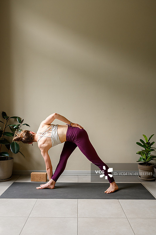 在家练习瑜伽的职业女性：旋转三角式图片素材
