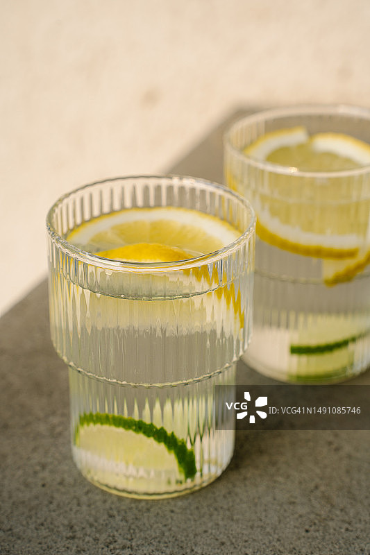 两杯柠檬和酸橙鸡尾酒，阳光下的露台图片素材