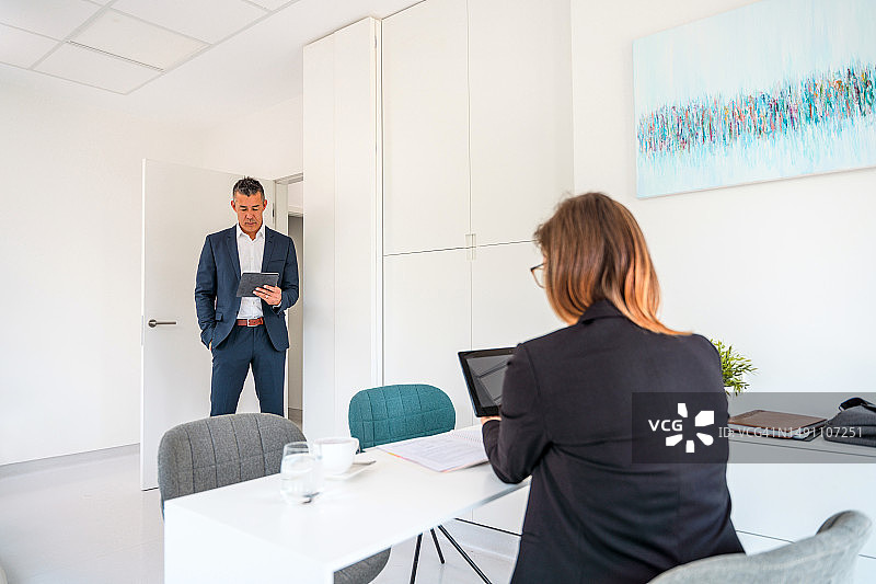 严肃的男商人与秘书谈论逾期合同图片素材