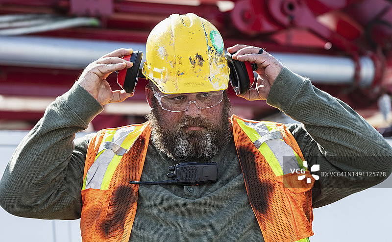 站在混凝土泵车旁的建筑工人图片素材