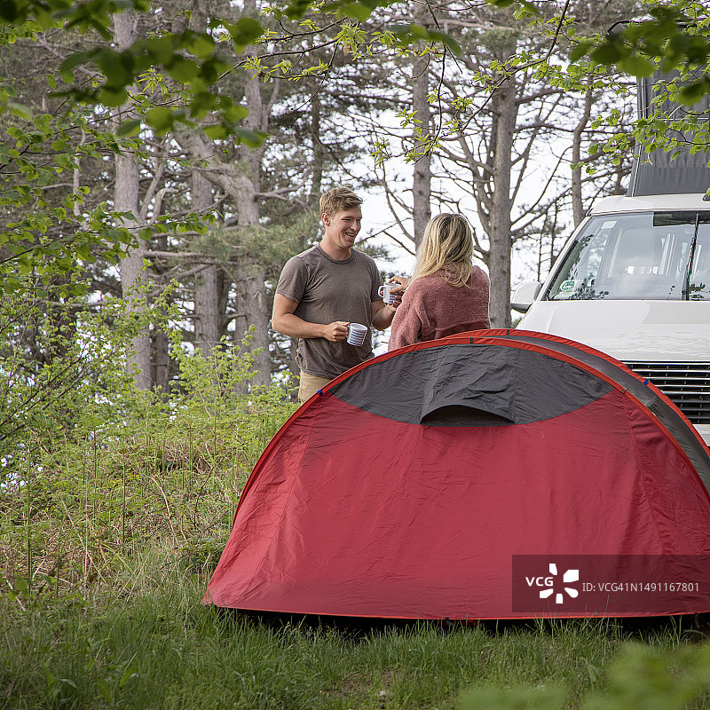 朋友们在森林里露营，享受热饮图片素材