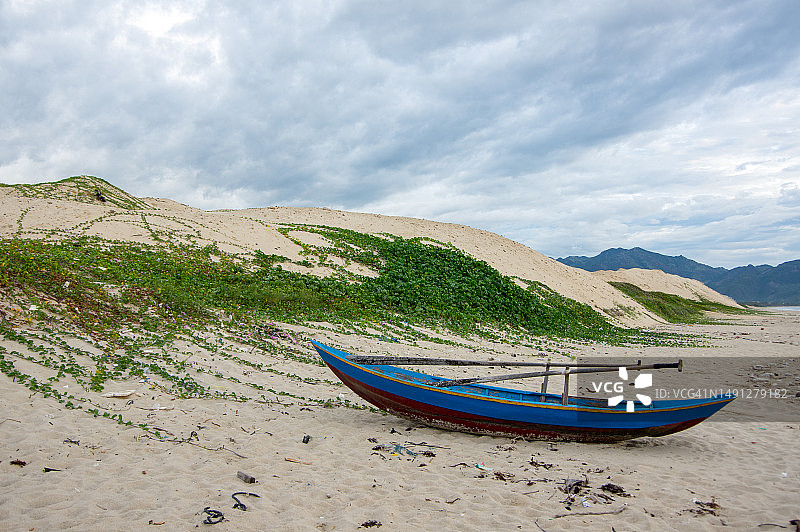 搁浅在白色沙丘上的小渔船图片素材