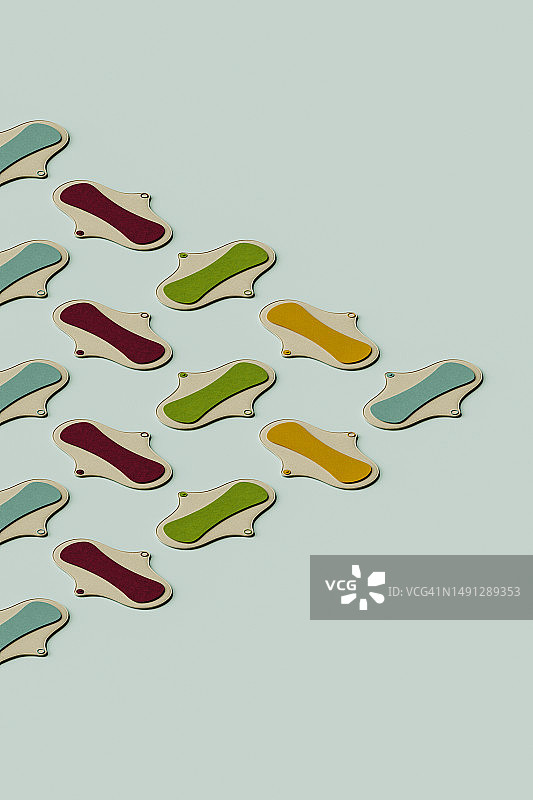 3D渲染：绿色背景上的黄色、红色和绿色卫生巾图片素材