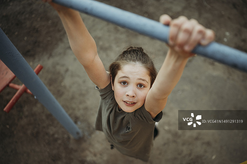 男孩在单杠上玩耍图片素材