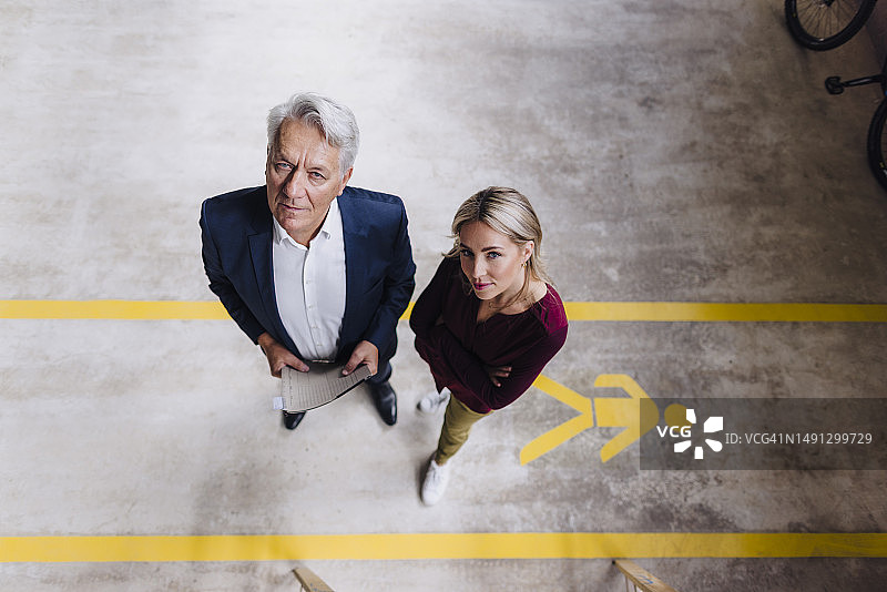 自信的女商人和年长的男商人在工厂车间图片素材