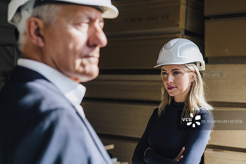 在木工工厂戴着安全帽的沉思女商人图片素材