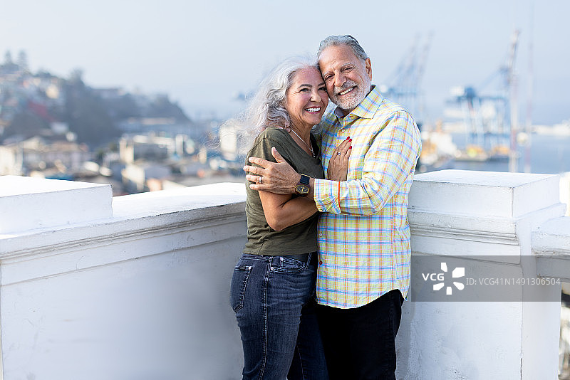 中年夫妇在屋顶露台上相拥微笑图片素材