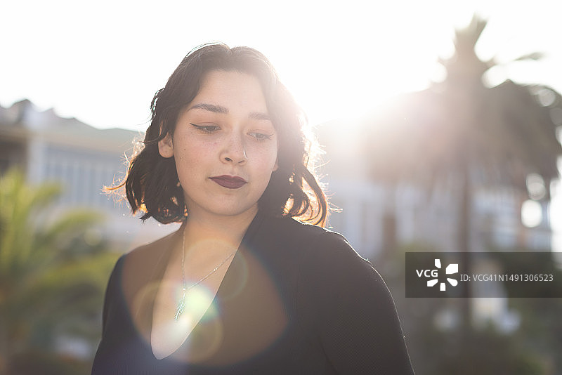 在热带地区镜头光晕前摆姿势的年轻女性图片素材