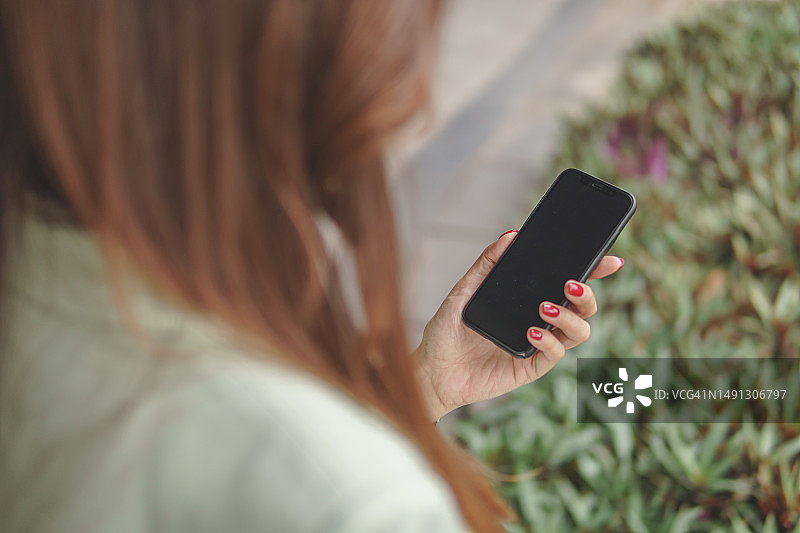 使用智能手机的亚洲女商人。自信的亚洲女性高管触摸空白屏幕。肩部以上视角图片素材