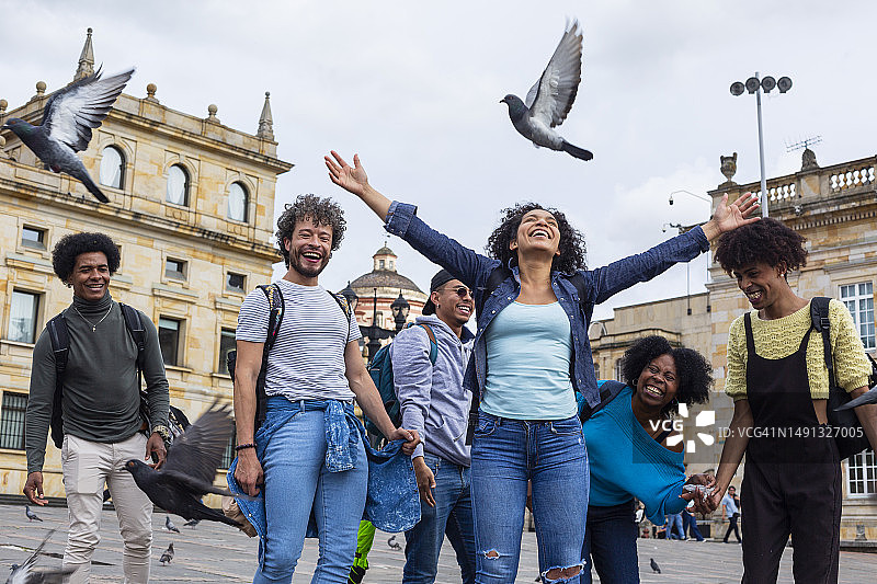 家庭游览美丽的波哥大，在玻利瓦尔广场喂鸽子图片素材