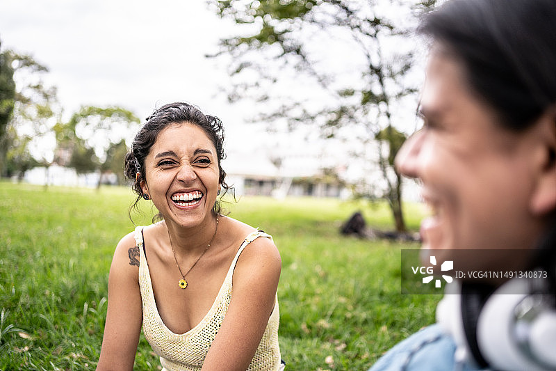 年轻女子在公园里与朋友交谈图片素材